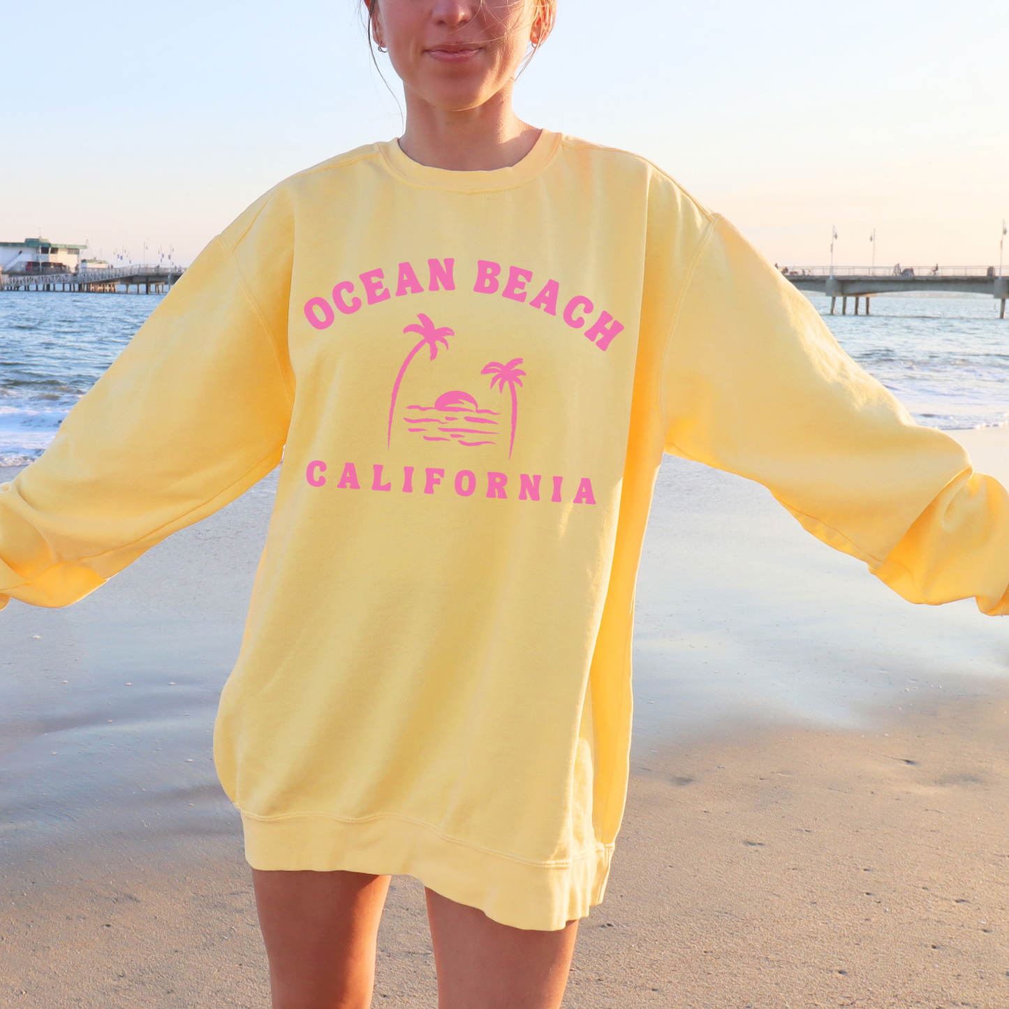 California girl in a Comfort Colors beach sweatshirt with pink Ocean Beach design